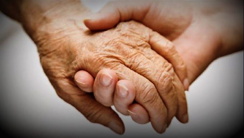 elderly holding hands with young person